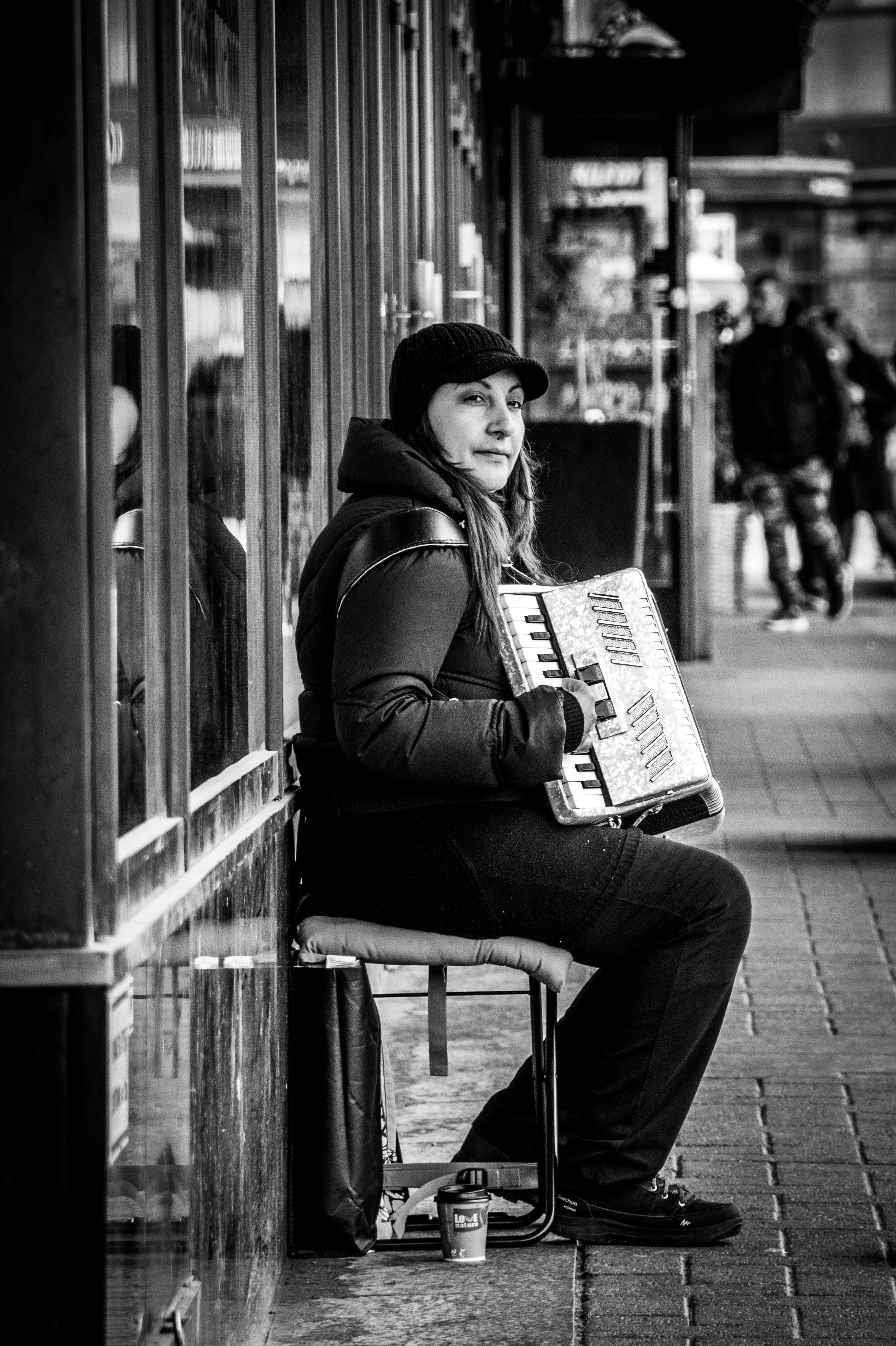 grayscale photo of woman reading book sitting on chair